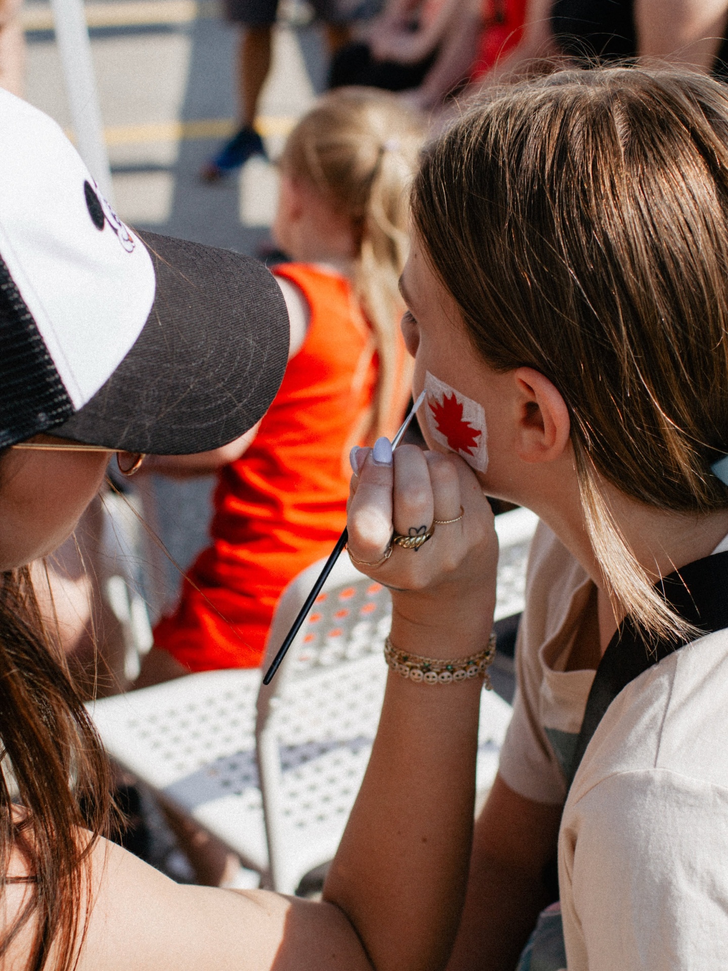 Child getting a Canada flag painted on their cheek